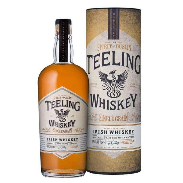 Teeling Single Grain Whiskey in a cream and white tin with brown text and an amber whiskey in a bottle with cream label.
